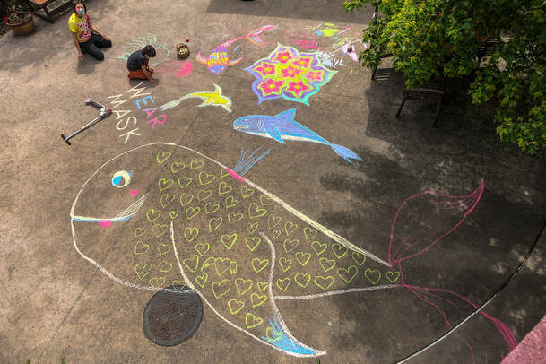 Kids doing chalk drawings on the pavement