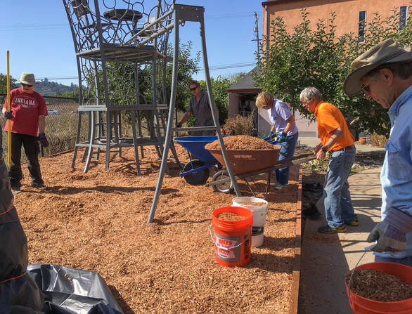 Residents working on the landscaape around a sculpture